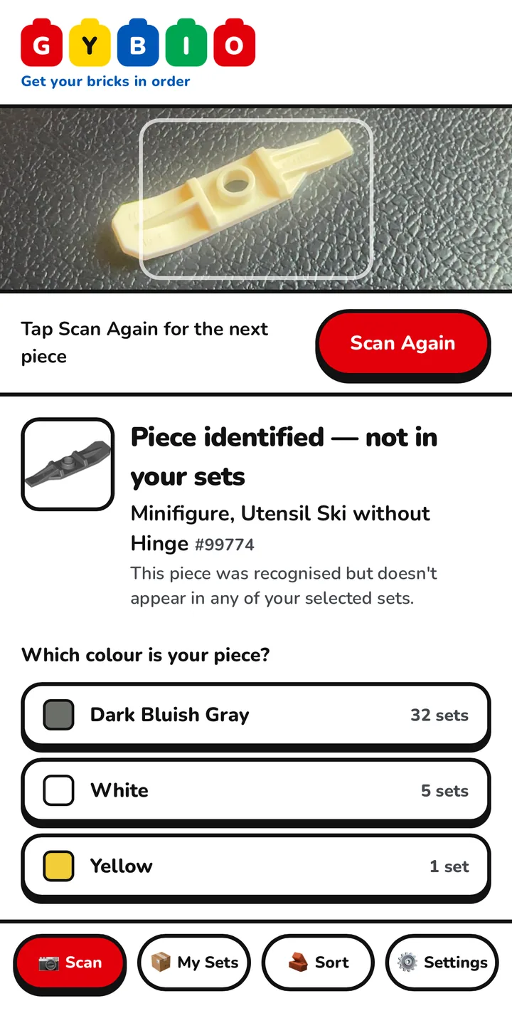 The Gybio scan screen with a cream LEGO piece in the camera frame, and a result below it saying the piece was identified but is not in the sets the owner has selected, followed by a list of colours and how many sets use each.