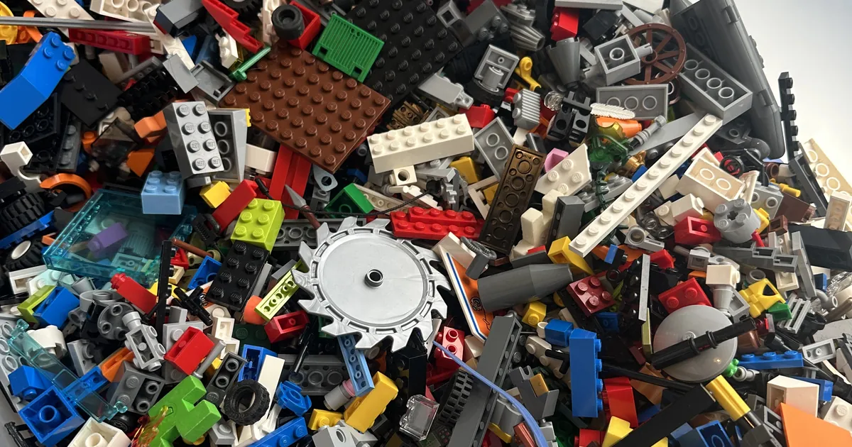A tub of mixed LEGO bricks from several sets, the kind of pile you need to sort before following an alternate build